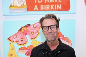 Don Purcell, owner of Don Purcell, in front of an Ashley Longshore piece of art