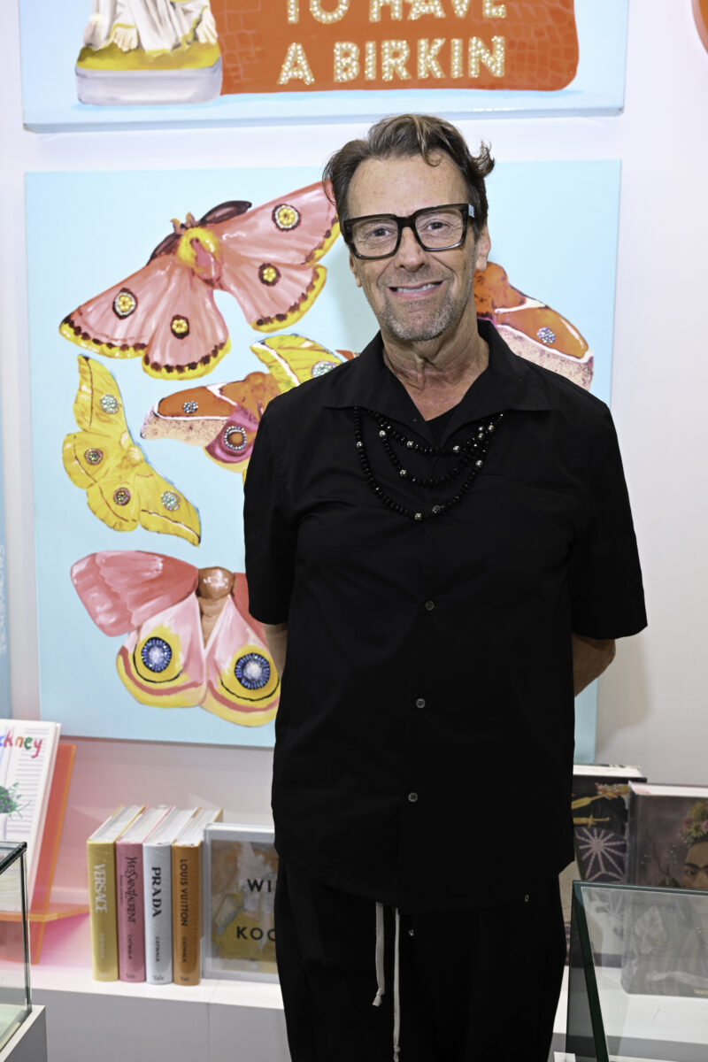 Don Purcell, the owner of Don Purcell, a fine jewelry, art, and gift boutique in Buckhead Village District, stands in front of an Ashley Longshore art piece. 