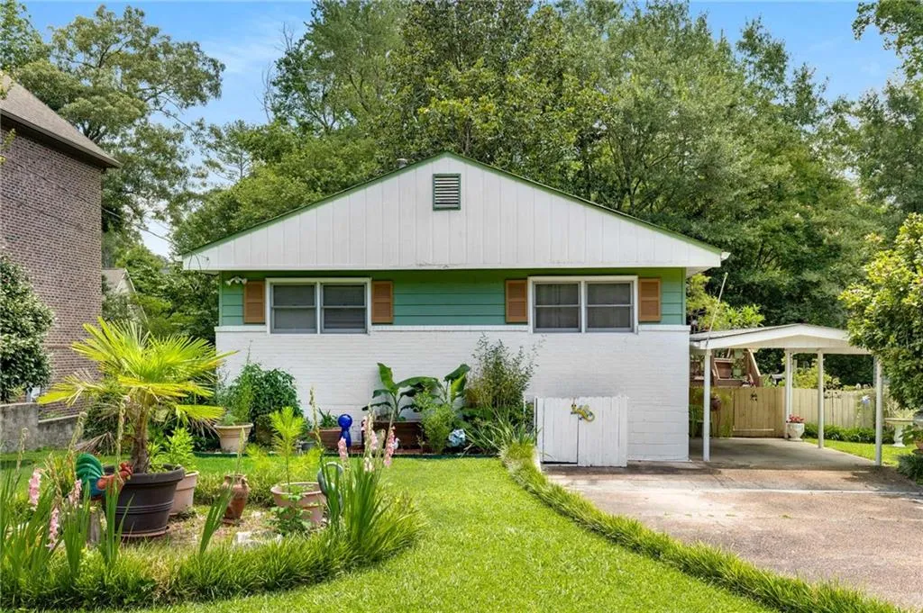 View of front facade featuring a carport, brick siding, and concrete driveway