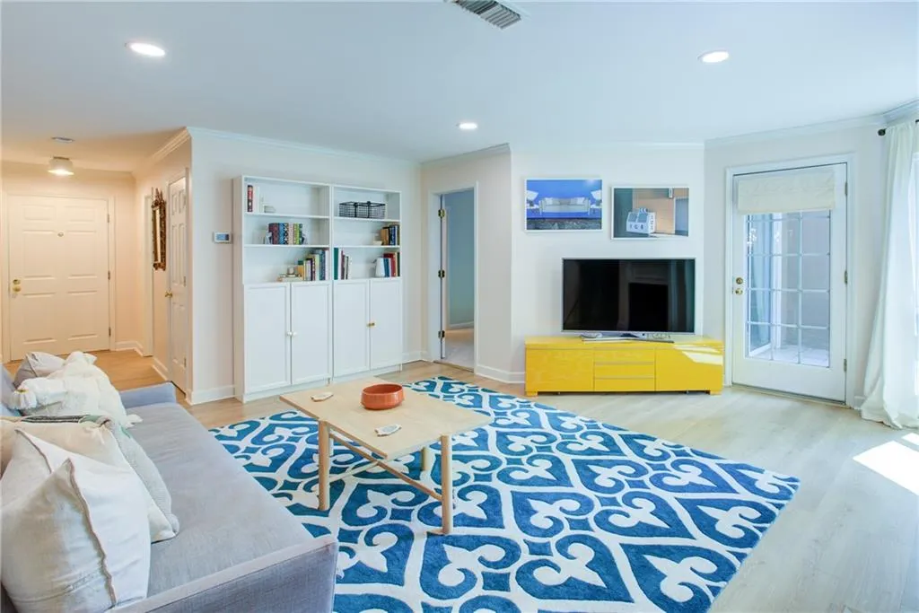 Living area featuring crown molding, wood finished floors, and recessed lighting
