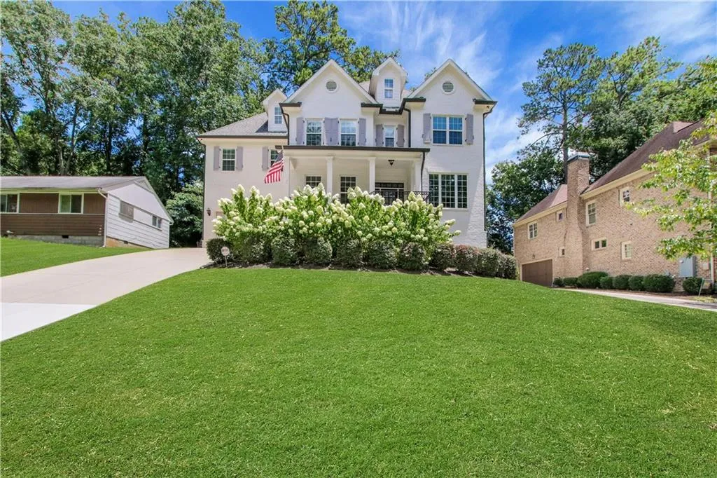 View of front of property featuring concrete driveway, a front lawn, and an attached garage