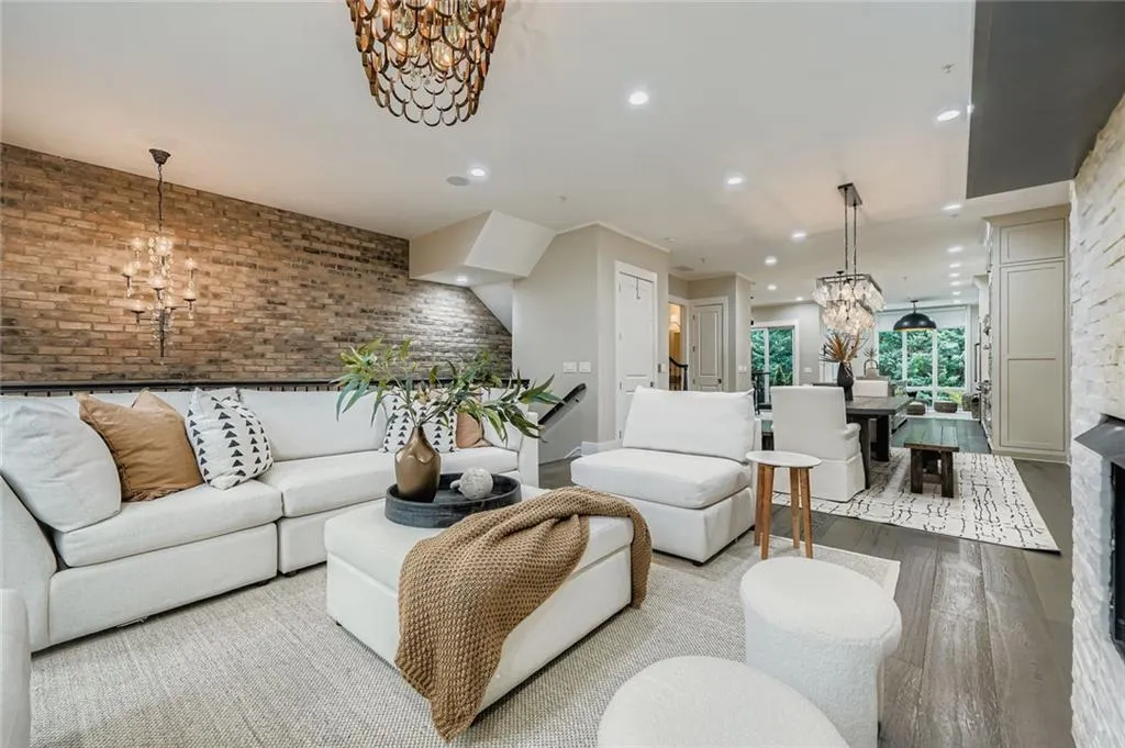 Living area with a chandelier, brick wall, wood finished floors, and recessed lighting