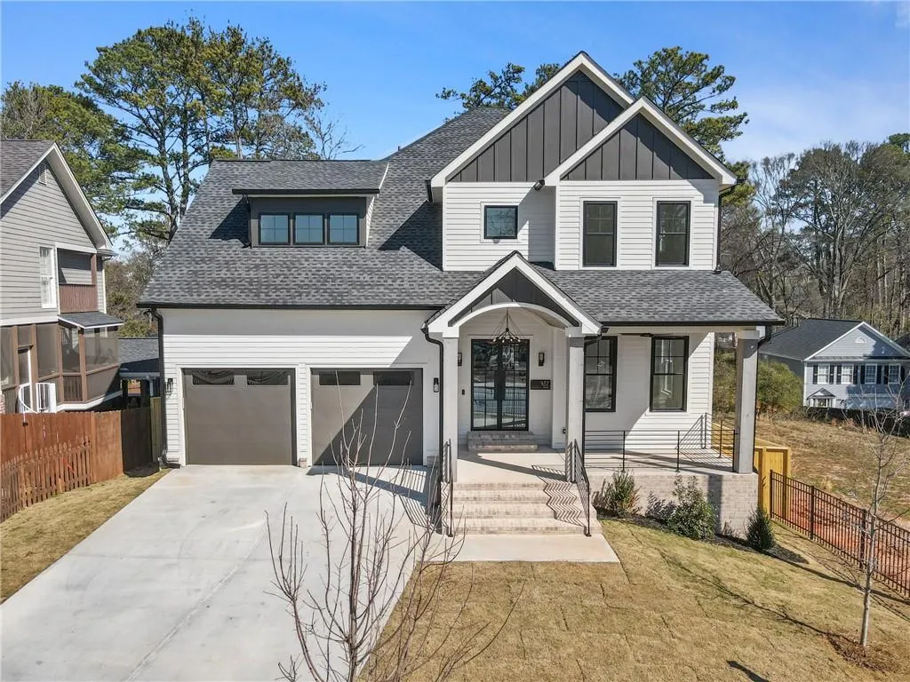 View of front of house with roof with shingles, a porch, driveway, and board and batten siding