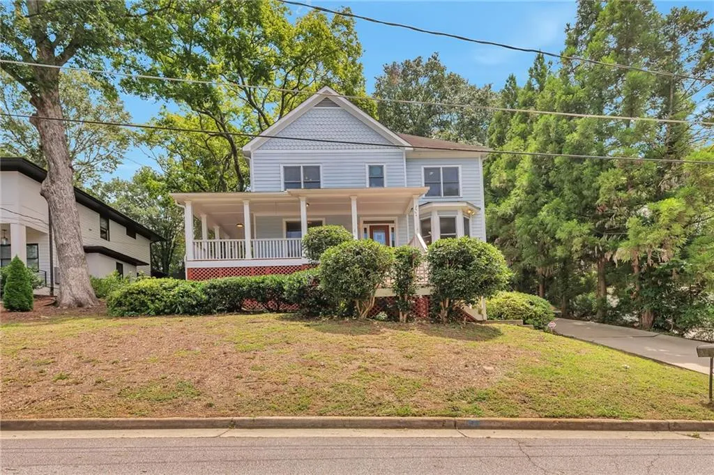 Victorian house featuring a porch and a front lawn