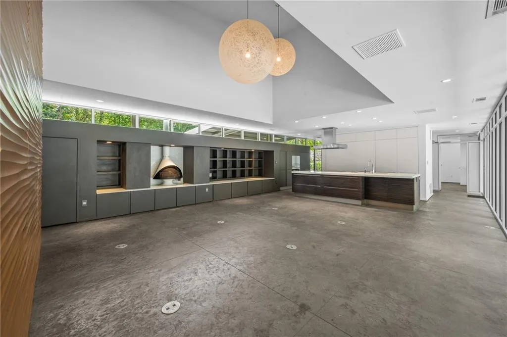 Unfurnished living room with concrete floors, recessed lighting, and a towering ceiling
